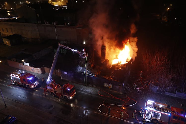 An Aerial Photography Of Fire Trucks On The Road At Night