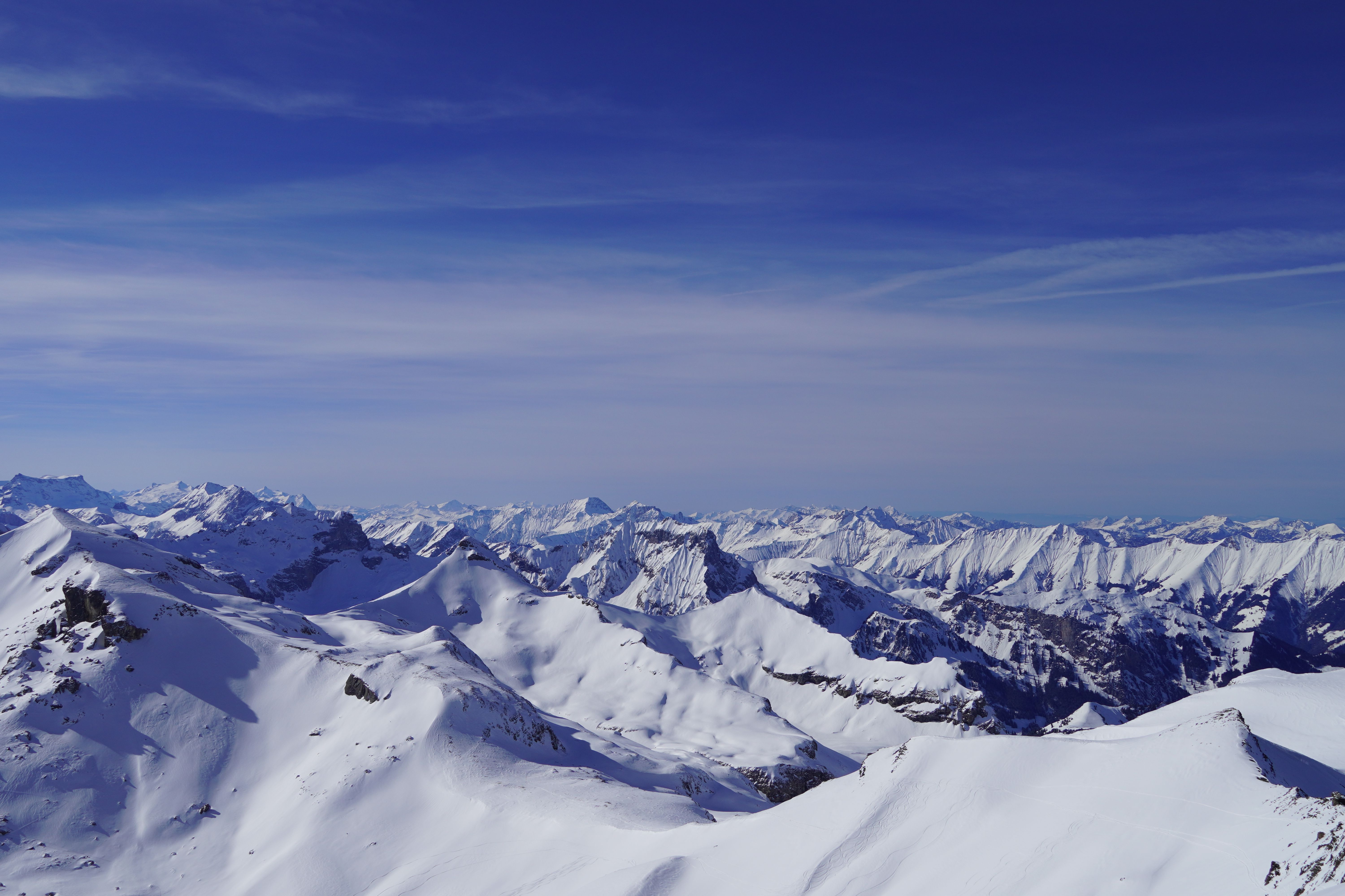 An Aerial Photography of a Snow Covered Mountain Under the Blue Sky ...