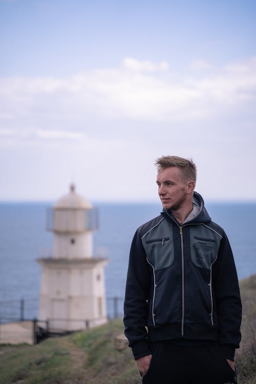 A Man in Black Jacket Standing Near the Lighthouse