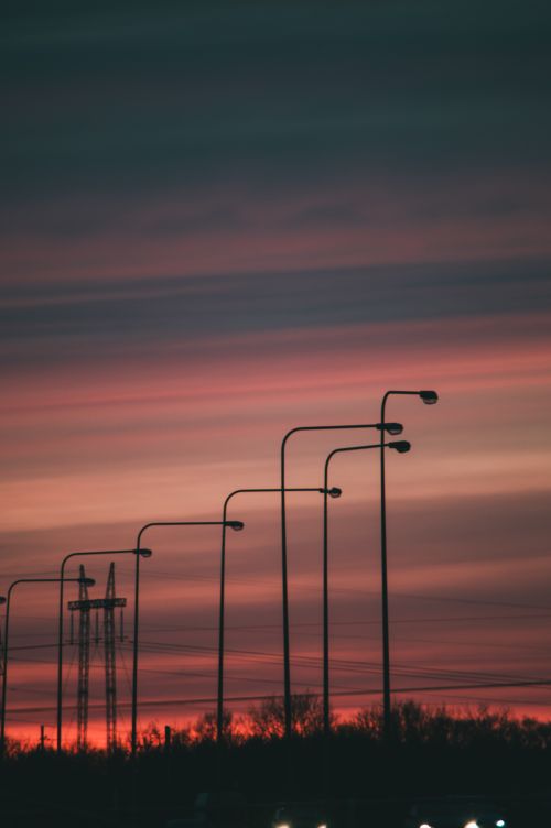 Free Vibrant dusk sky with silhouetted streetlights in Lithuania's picturesque setting. Stock Photo