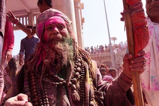 Portrait of a man celebrating Holi festival, covered in vibrant colors during an outdoor event.