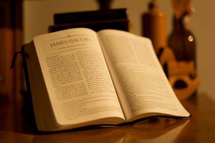 An open Bible resting on a wooden table