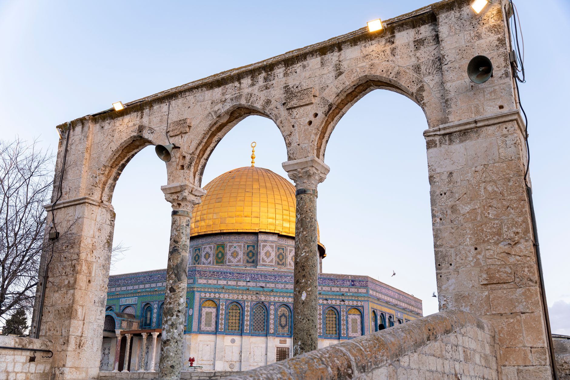 Capture of the Dome of the Rock framed by historic stone arches in Jerusalem.