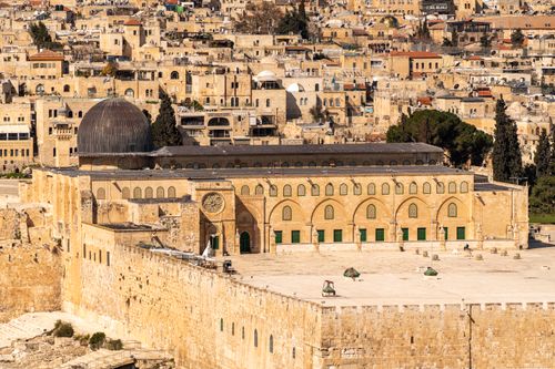 Free Scenic view of the Al-Aqsa Mosque amidst the historic architecture of Jerusalem's Old City, bathed in warm daylight. Stock Photo