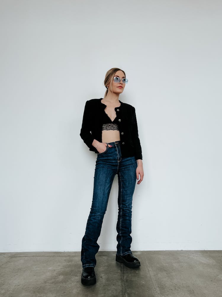 A Woman In Unbutton Black Cardigan And Denim Jeans