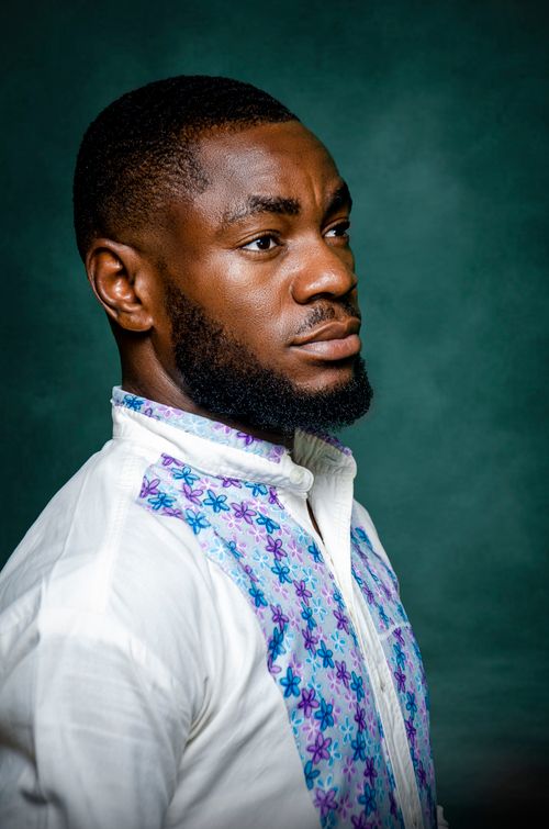 Free Side profile portrait of a fashionable black man in a floral top against green background. Stock Photo