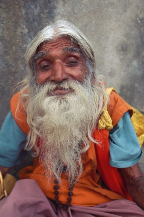 Free Close-up of a cheerful elderly man with a long gray beard and vibrant clothing. Stock Photo