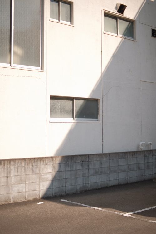 Free Urban building exterior with windows, concrete, and sunlight casting shadows. Stock Photo