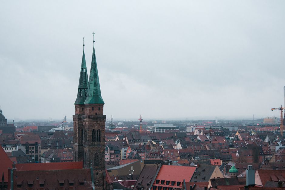 Aerial view of St. Sebaldus Church amidst the historic Nuremberg cityscape on a cloudy day.