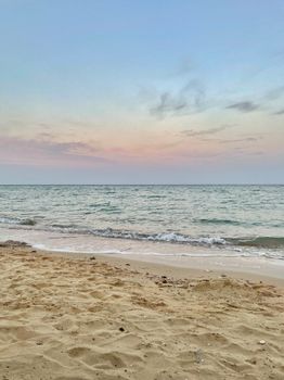 Tranquil beach scene at sunrise with gentle waves and a pastel sky. Perfect for relaxation themes.