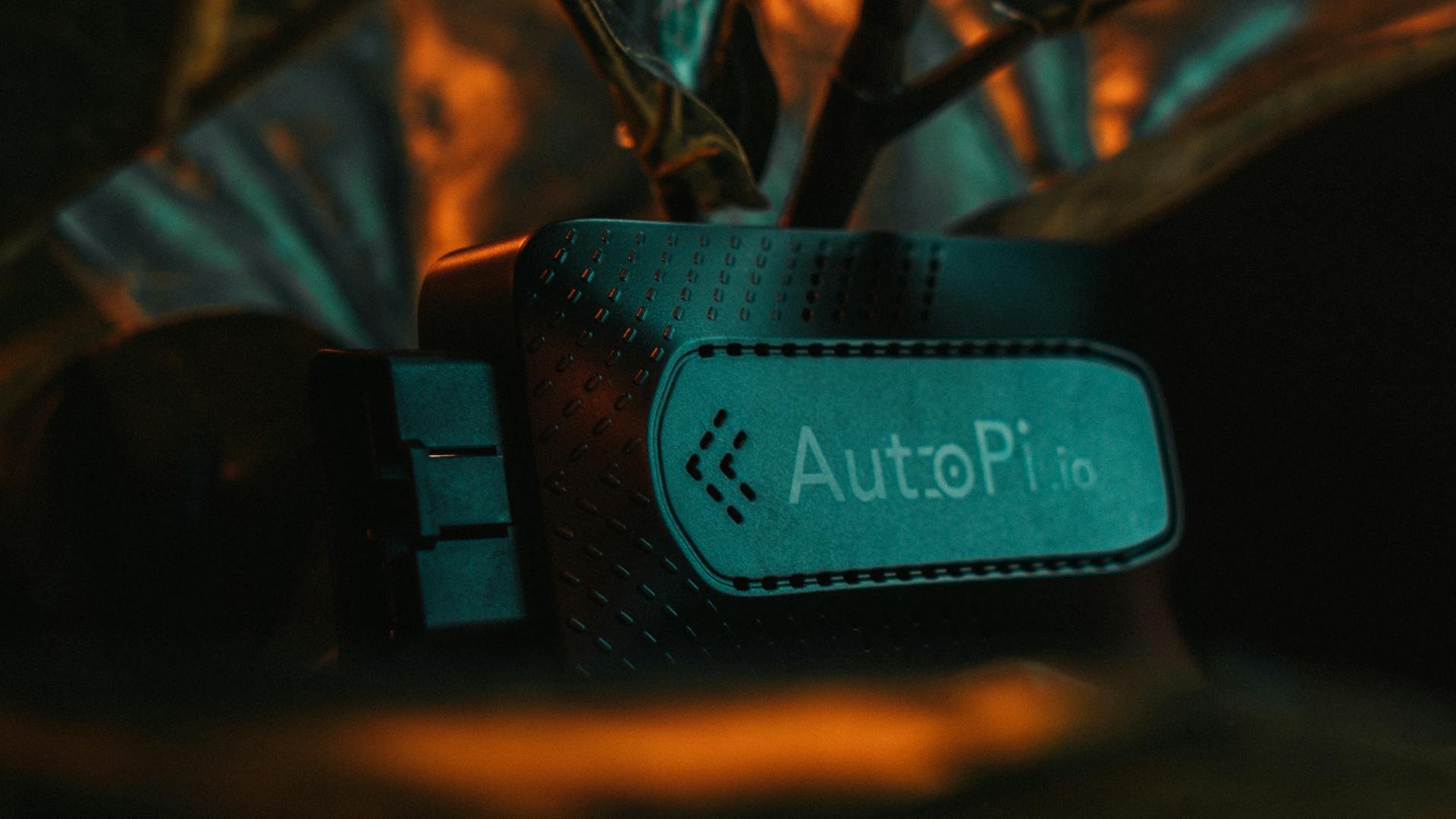 Detailed macro shot of an AutoPi device against a dark background, showcasing technological innovation.