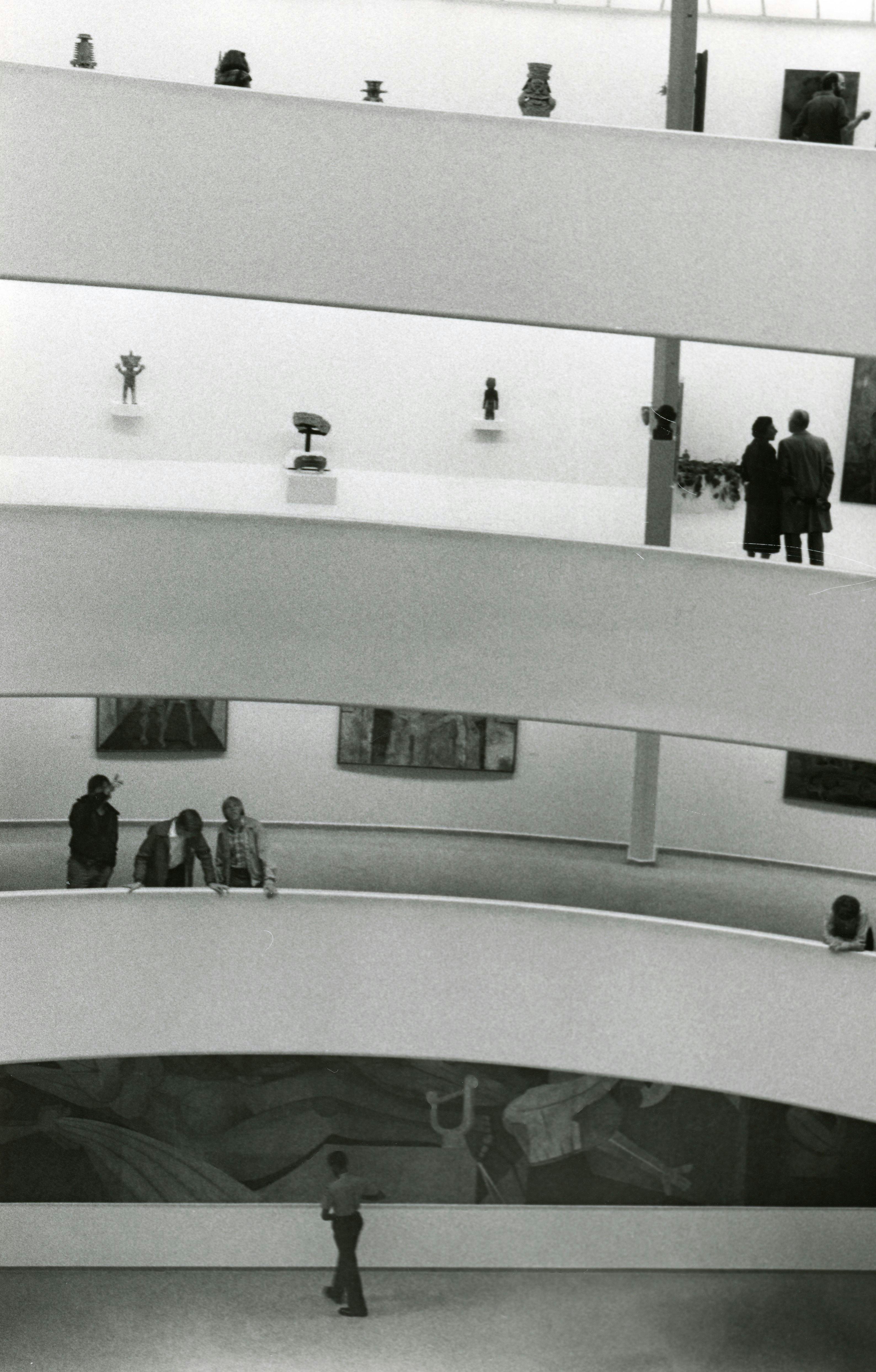 a grayscale photo of people inside the museum