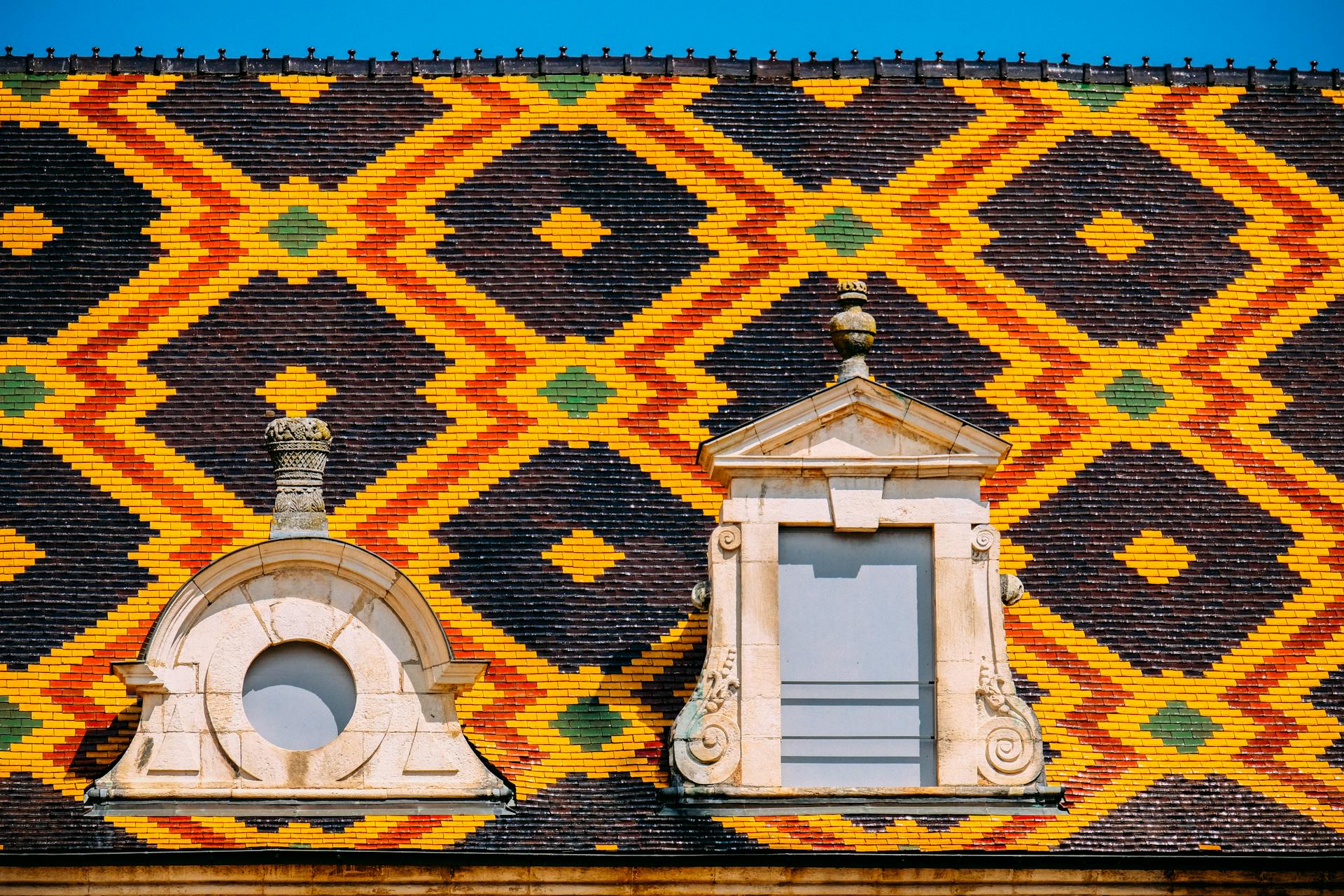 Colorful geometric design on historic tiled roof in Beaune, France.