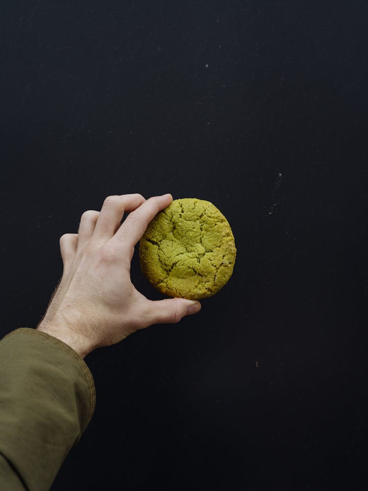 A Person Holding A Green Cookie