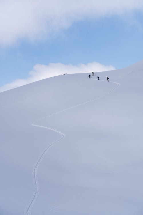 Free Climbers Walking Uphill on a Snow Covered Mountain Stock Photo