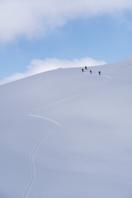 Climbers Walking Uphill on a Snow Covered Mountain