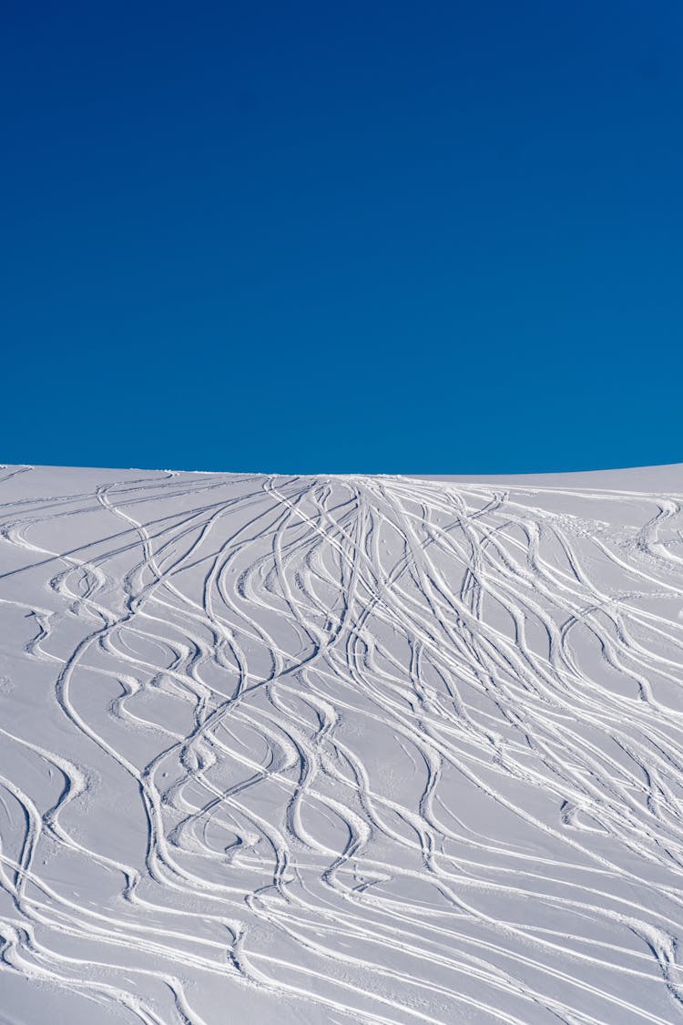 Snowy Ski Slopes Under Blue Sky