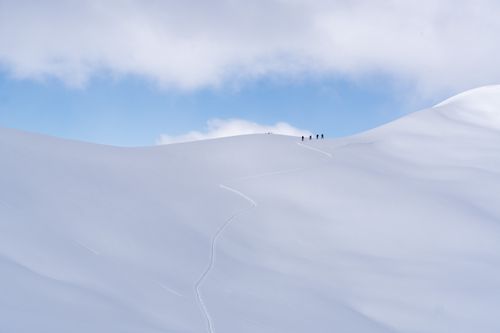 Free Adventure enthusiasts hiking through the serene snowy landscapes of Davos, Switzerland. Stock Photo
