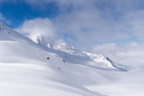 Free Serene winter landscape of snowcapped mountains under a bright blue sky. Stock Photo