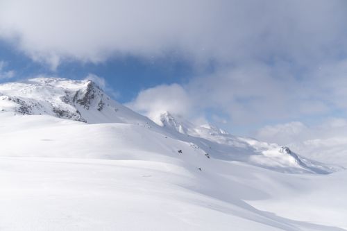Free Beautiful snowy mountain range under a bright blue sky, showcasing winter's serene beauty. Stock Photo