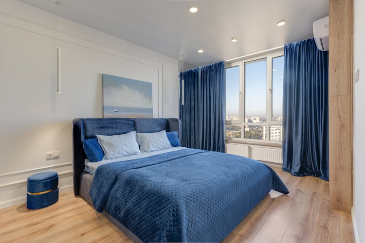 Bed With Blue Sheets In Bedroom