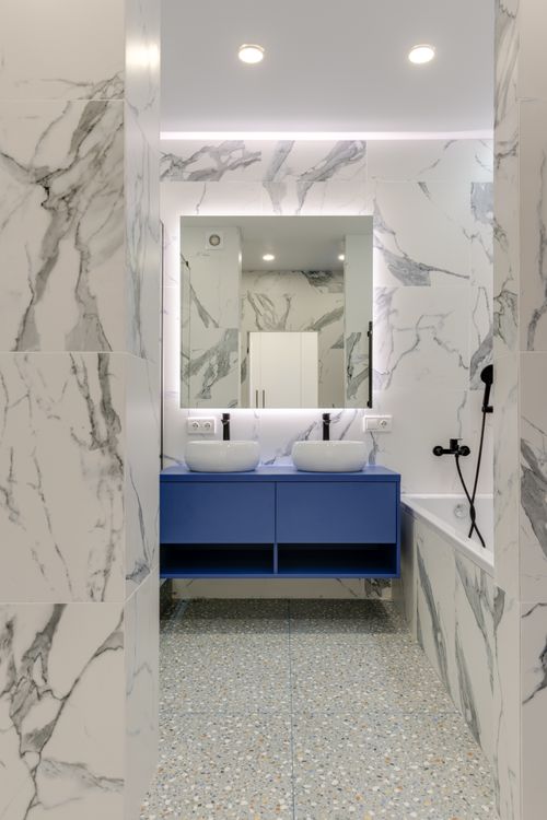 Free Stylish marble bathroom with blue vanity and double sinks. Stock Photo
