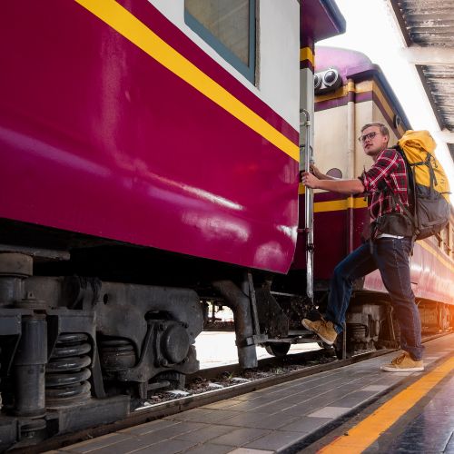 Voyageur avec sac à dos montant dans un train — toujours en mouvement