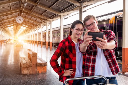 Man and Woman Taking Selfie Near Gray Train