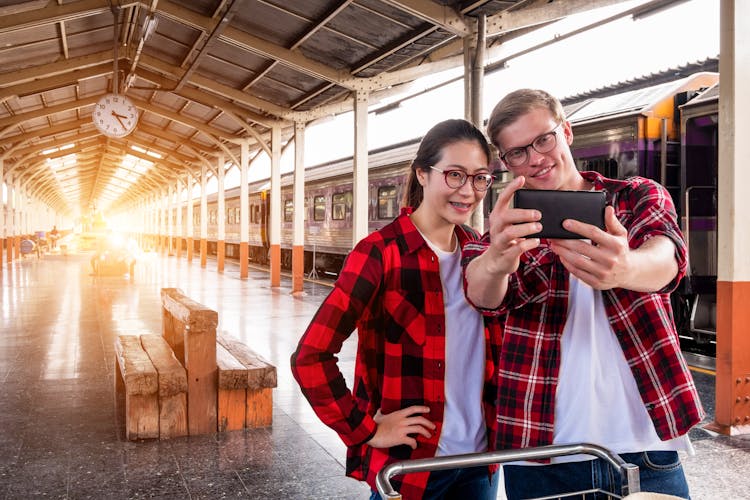 Man And Woman Taking Selfie Near Gray Train