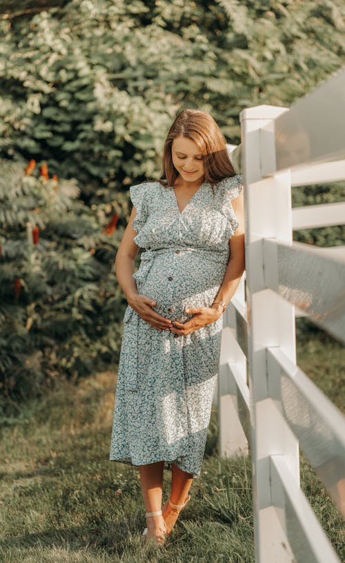 Free Pregnant Woman Holding and Looking at Her Belly Stock Photo