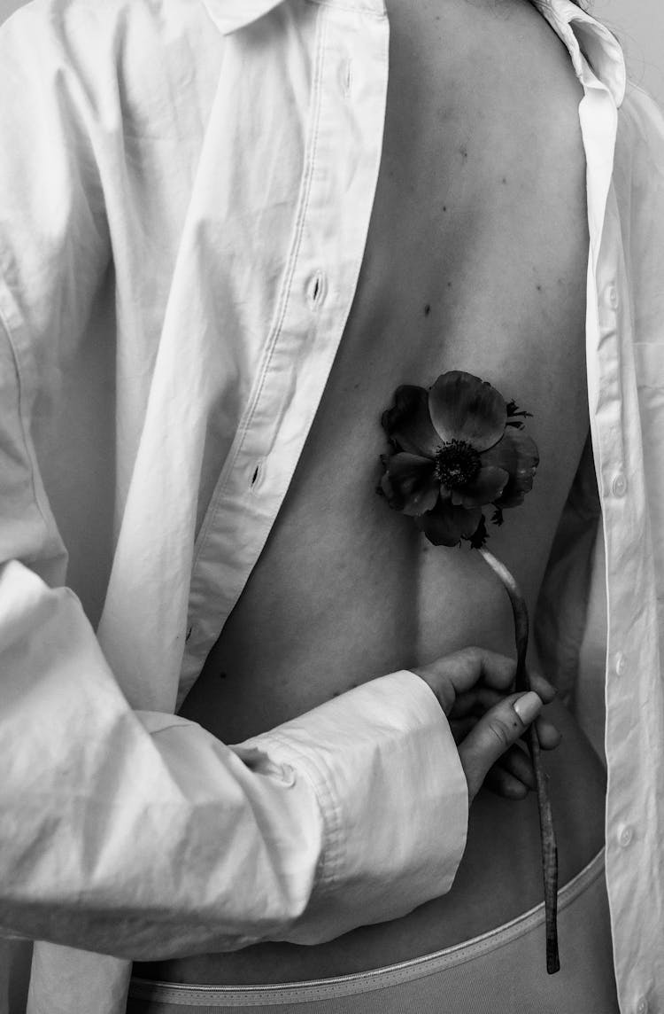 A Grayscale Photo Of A Person Holding A Flower