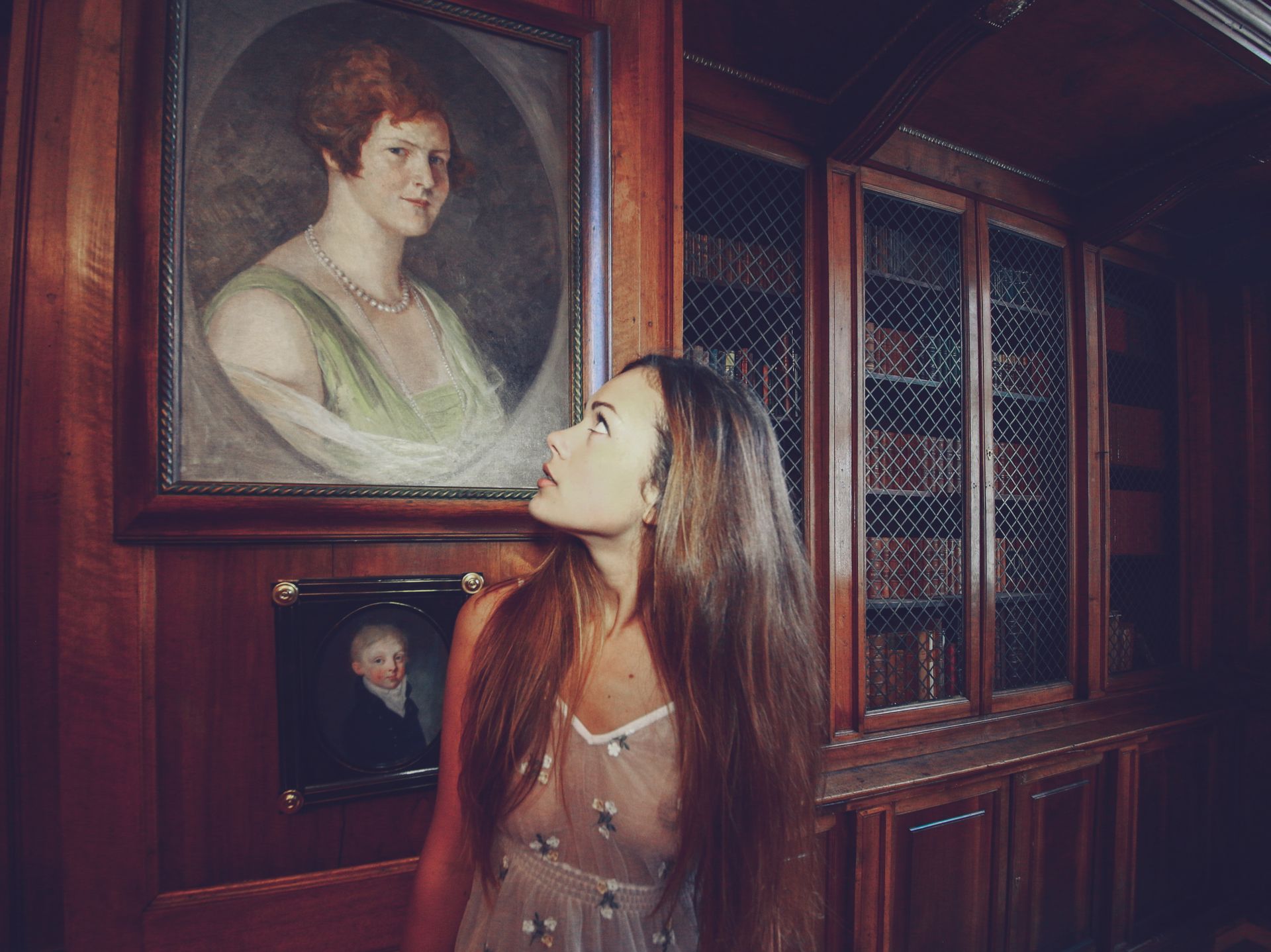 A Woman in White See Through Clothes Looking at the Picture Hanging on the Wall