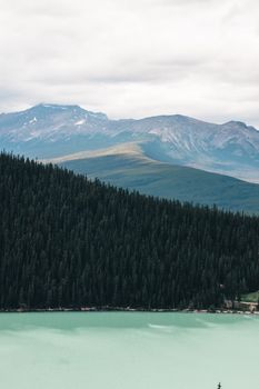 Breathtaking view of forested mountains and turquoise lake in Alberta, Canada.