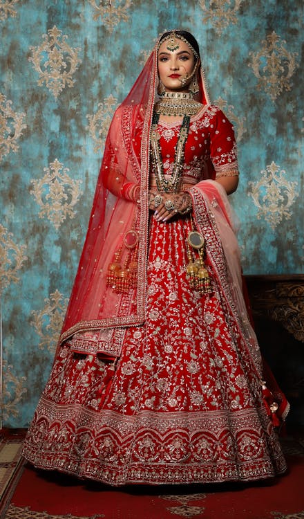 Free A Beautiful Bride Standing while Wearing a Lehenga Stock Photo