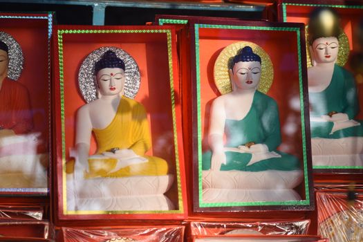 Vibrant Buddha figurines displaying spirituality and culture on a store shelf.