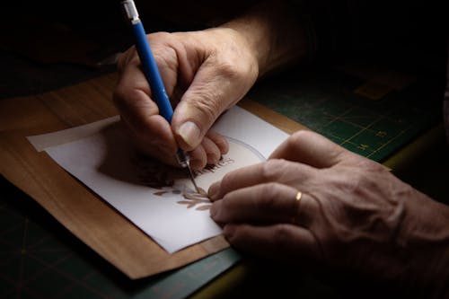 Close-up of Person Drawing Logo on Paper