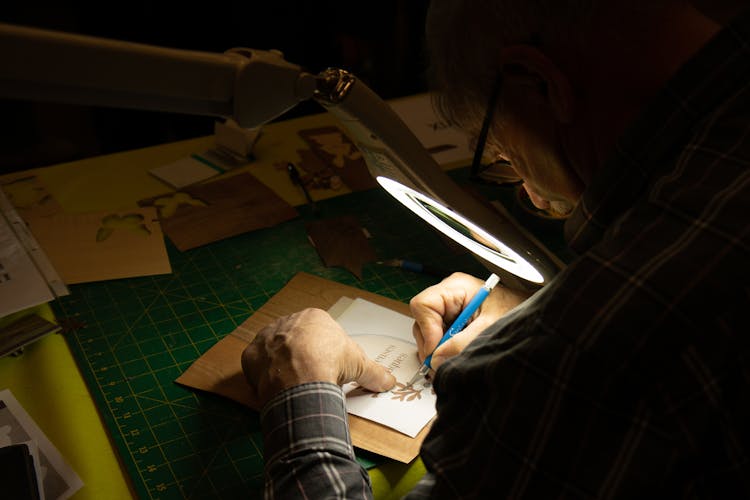 A Man Writing On A Card