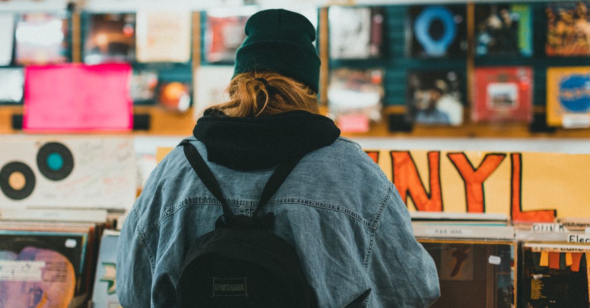 young person browsing vinyl records in record store crates