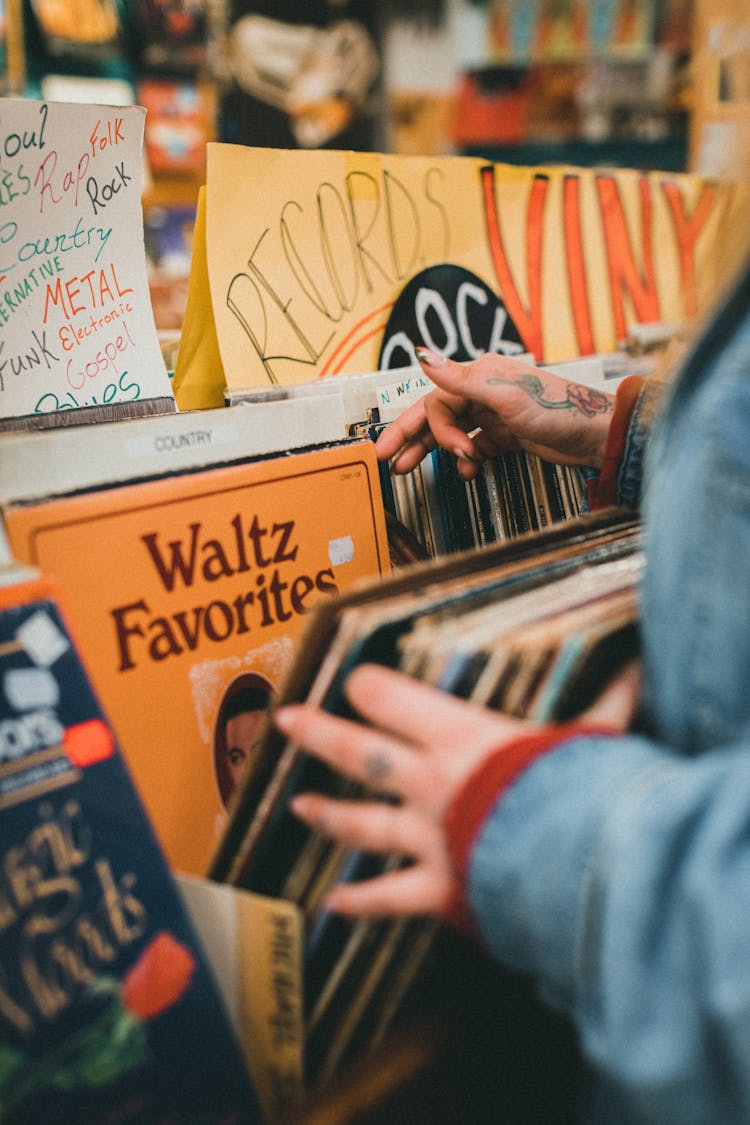 Woman Choosing Vinyl Plates In Shop