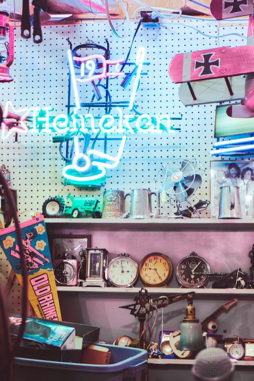 Free Colorful display of vintage clocks and a Heineken neon sign in a collectibles store. Stock Photo