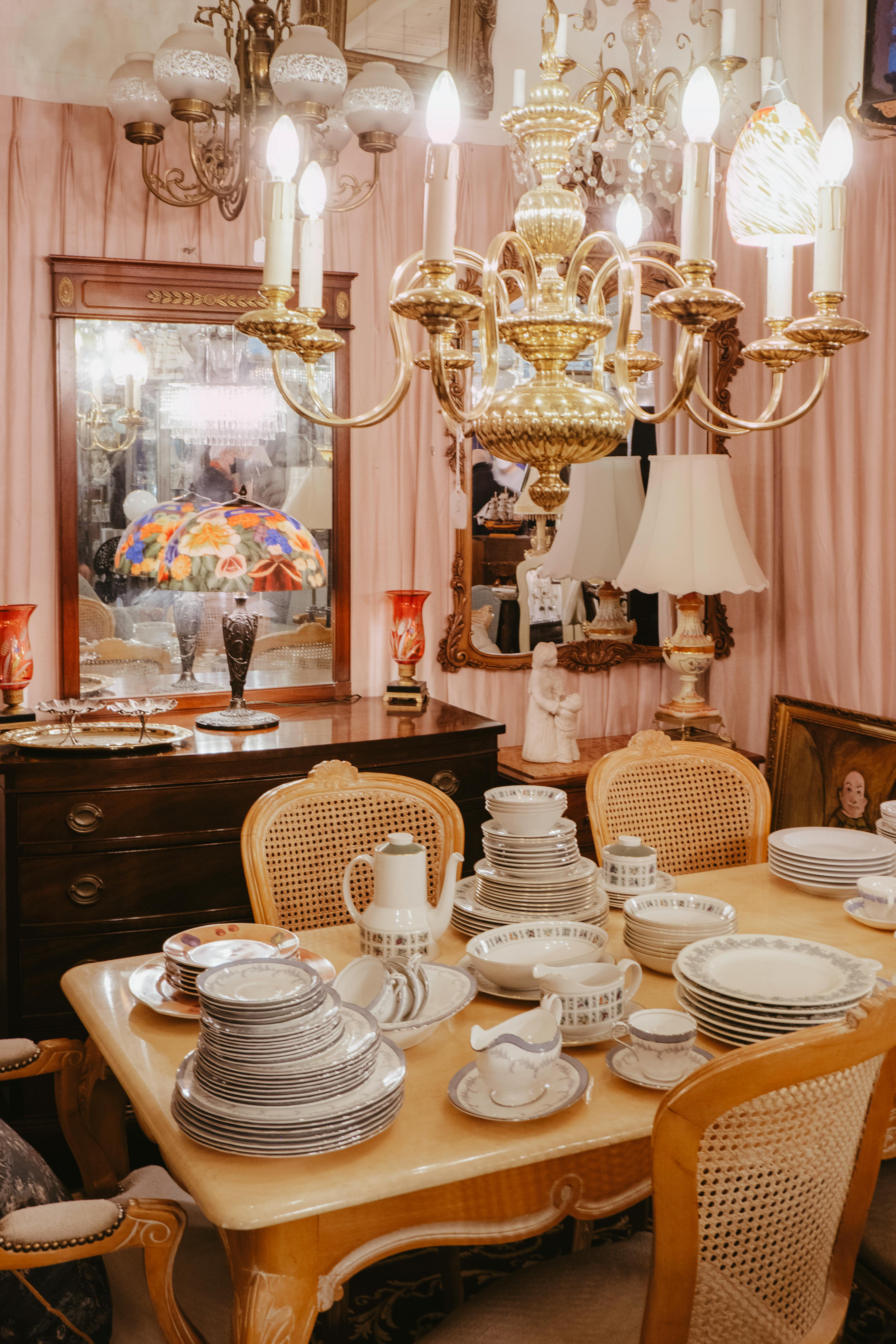 A lavish dining room featuring an ornate chandelier and classic table setting with fine china.