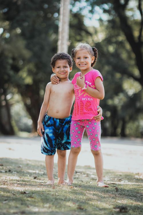 Free Two smiling children enjoying a sunny day in the park, barefoot and cheerful. Stock Photo