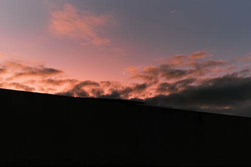 Free A beautiful Brazilian sunset with a crescent moon and dramatic clouds. Stock Photo
