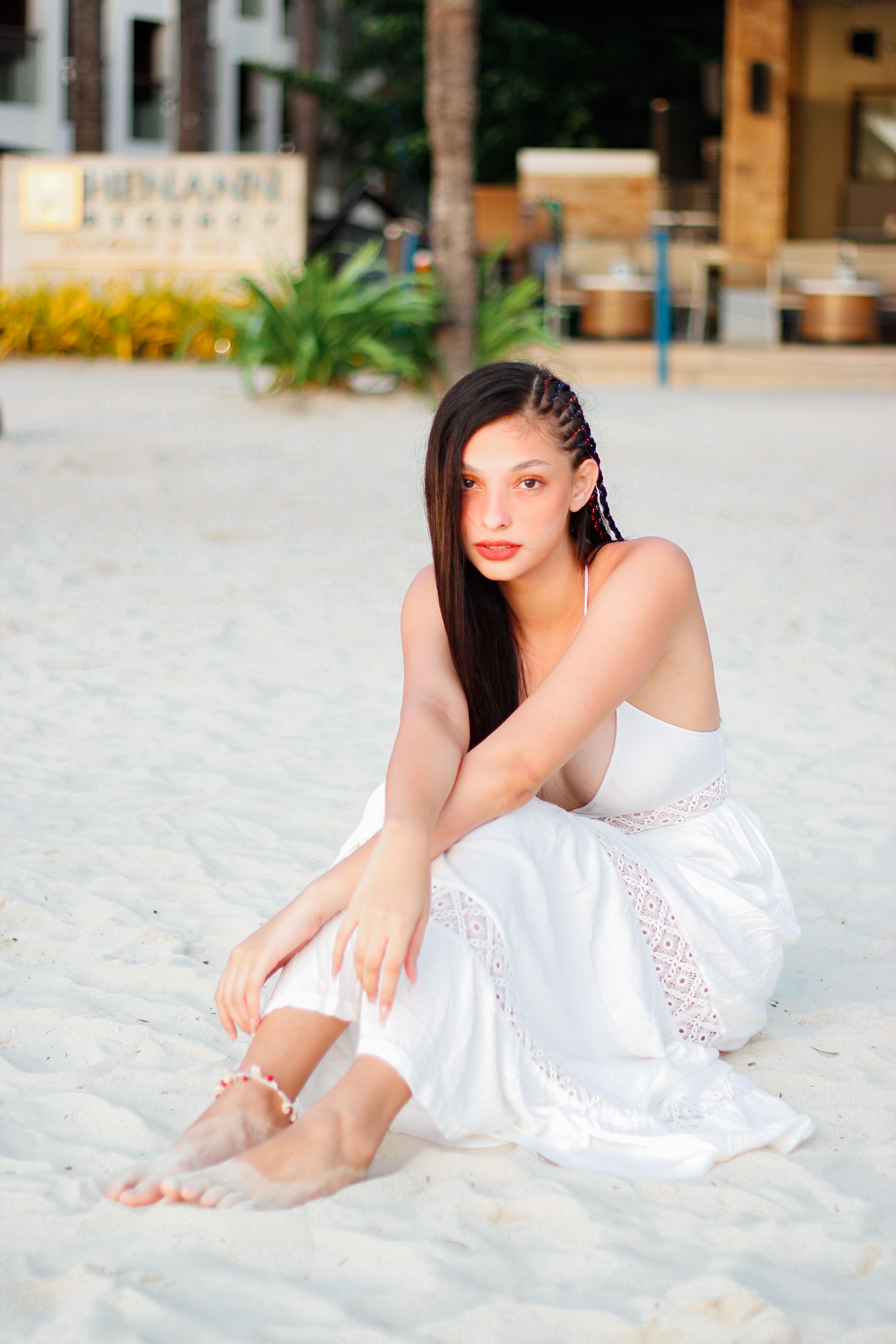 A Woman in White Dress Sitting on Sand · Free Stock Photo