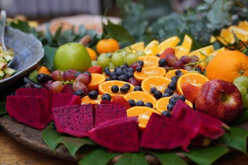 Free A colorful array of fresh fruits including dragon fruit, oranges, grapes, and berries displayed beautifully on a platter. Stock Photo