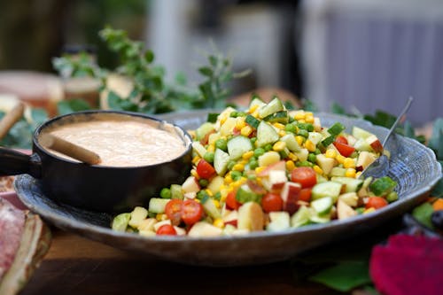 A Vegetable Salad on a Bowl with Sauce on the Side