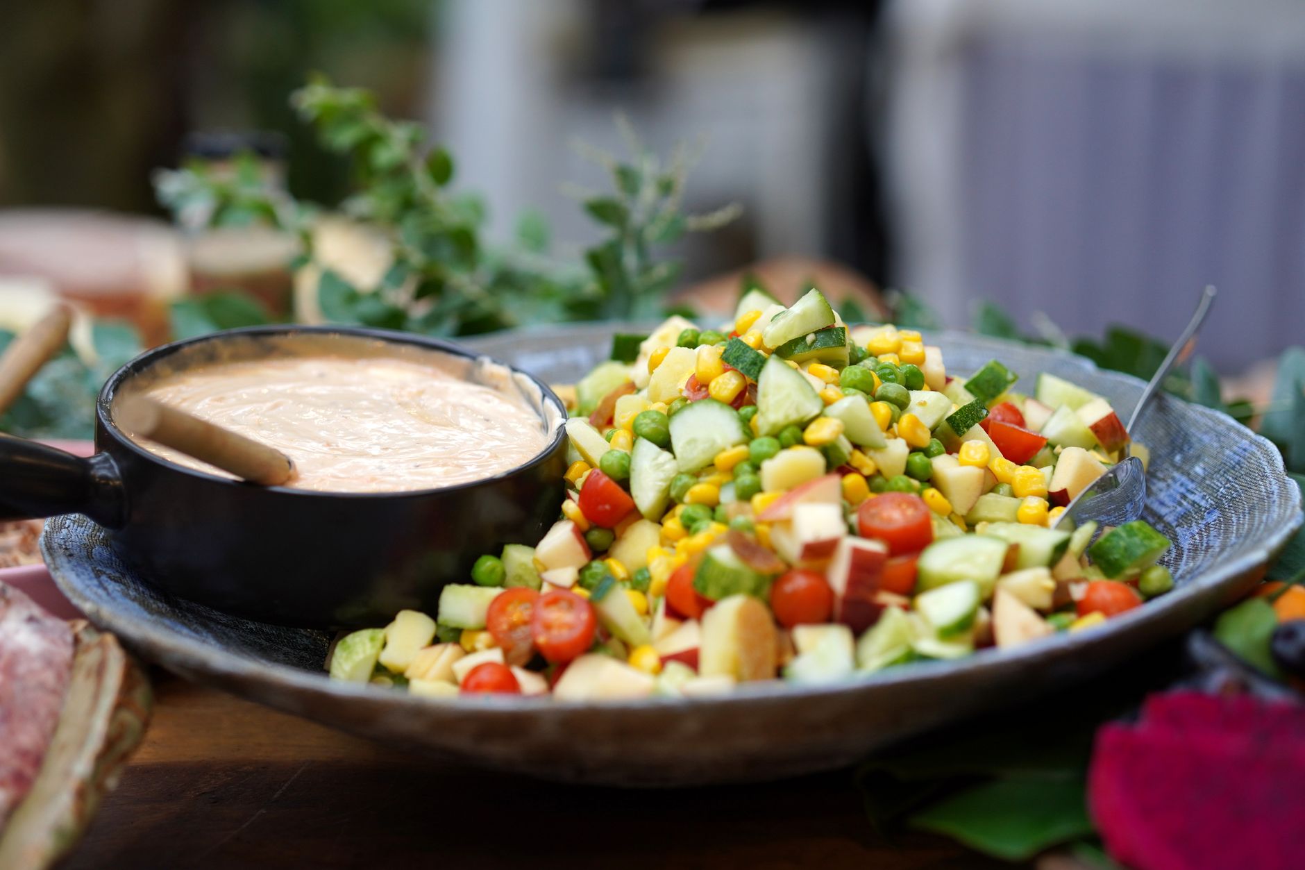 Creamy Cheesy Jalapeño Cashew Dressing Recipe Colorful vegetable salad paired with creamy dressing in a rustic setting.