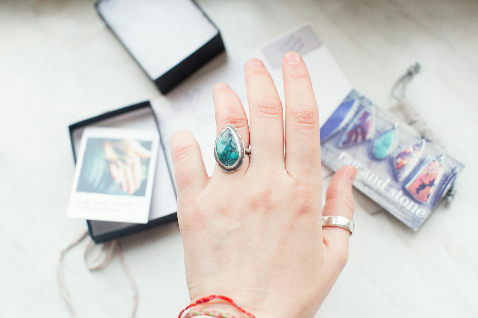 A detailed shot of a hand wearing a turquoise gemstone ring, showcasing jewelry design.