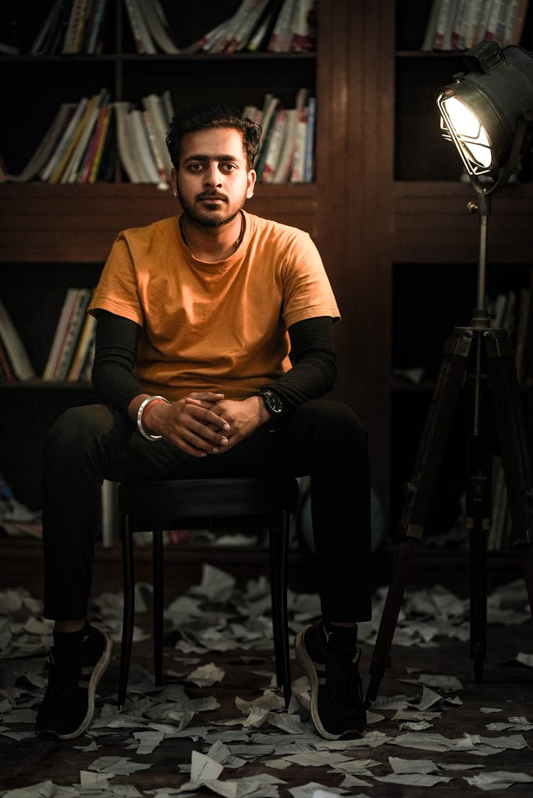 Torn Pages Of Books Under A Man Sitting On A Chair