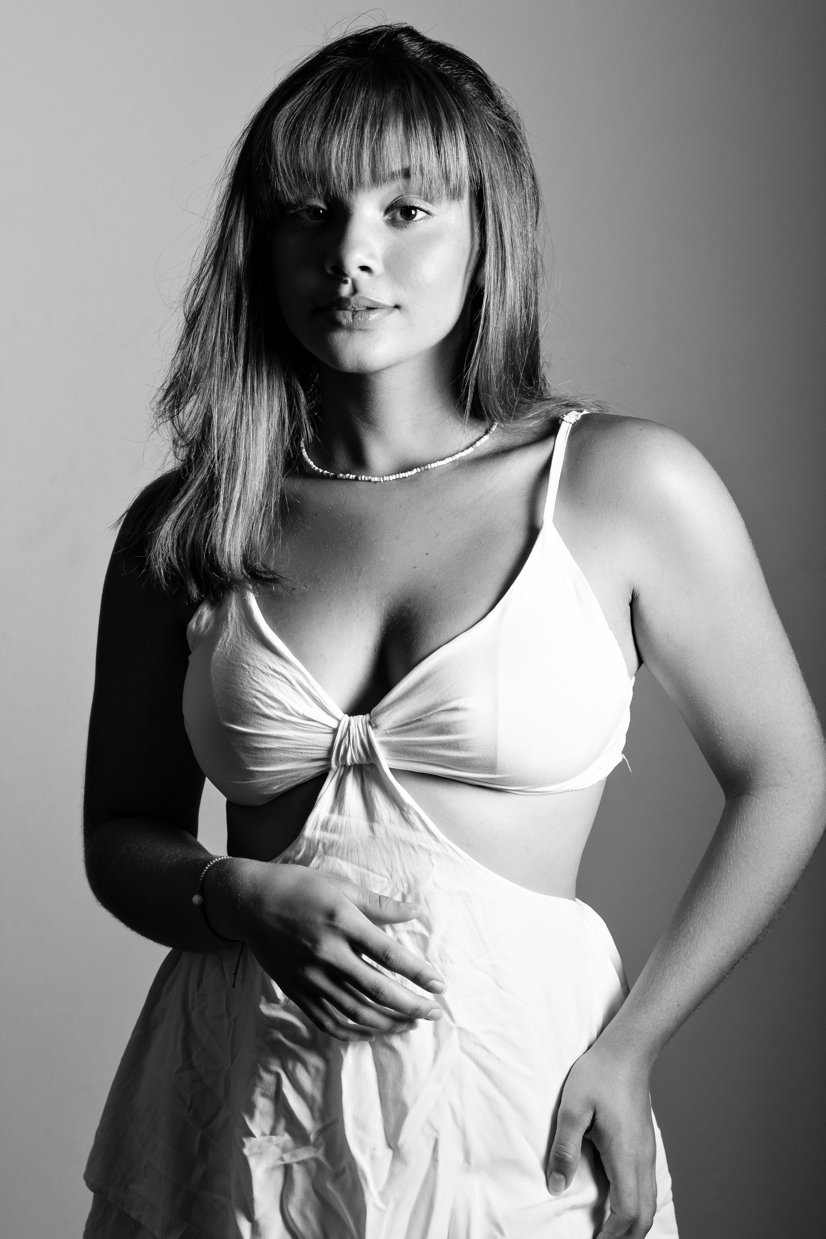 Black and white portrait of a woman in a studio, highlighting her elegance and style.